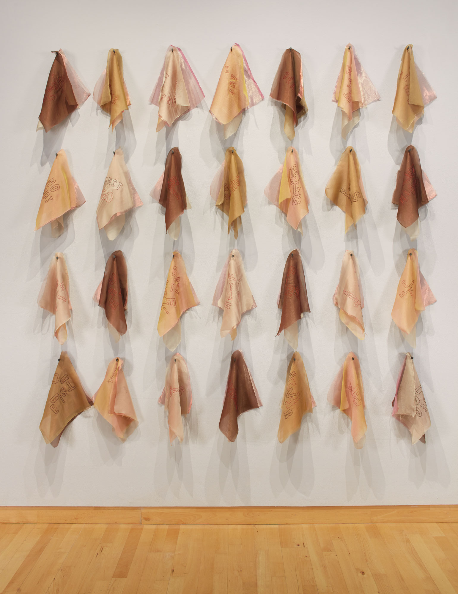 Rosemarie Chiarlone, Consequence, 2019. embroidered silk organza sewn to silk chiffon leaves, masonry nails. text by poet Susan Weiner. 14 x 14 in., each of 28 fabric pieces; 112 x 90 x 7 in. as installed. Courtesy of the artist and Priscilla Juvelis Rare Books. Installation view of Skyway 20/21 exhibition at USF Contemporary Art Museum. Photo: Will Lytch.